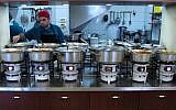 A cook tends to pots of food in the kitchen of the Azura restaurant in Jerusalem's Mahane Yehuda market, March 26, 2014. (photo credit: AP/Aron Heller)