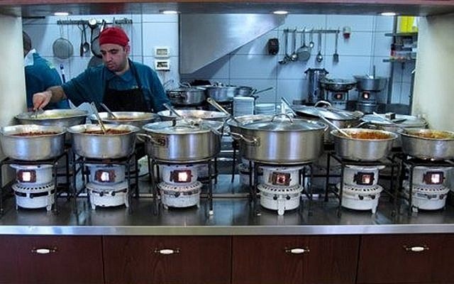 A cook tends to pots of food in the kitchen of the Azura restaurant in Jerusalem's Mahane Yehuda market, March 26, 2014. (photo credit: AP/Aron Heller) A cook tends to pots of food in the kitchen of the Azura restaurant in Jerusalem's Mahane Yehuda market, March 26, 2014. (photo credit: AP/Aron Heller)