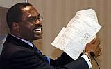 In this Jan. 29, 2004 file photo, former boxer, Rubin, "Hurricane" Carter, holds up the writ of habeas corpus that freed him from prison, during a news conference held in Sacramento, Calif. (photo credit: AP Photo/Rich Pedroncelli, File)