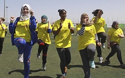 American track and field great Jackie Joyner-Kersee, center, jogs with Palestinian women in the West Bank city of Ramallah, Thursday, April 17, 2014. (photo credit: AP Photo/Nasser Shiyoukhi)