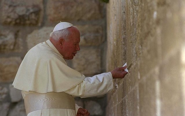 Pope John Paul II places a letter between the stones of Jerusalem’s Western Wall on March 26, 2000. (photo credit: Amos Ben Gershom/Israel Government Press Office via Getty Images/JTA)