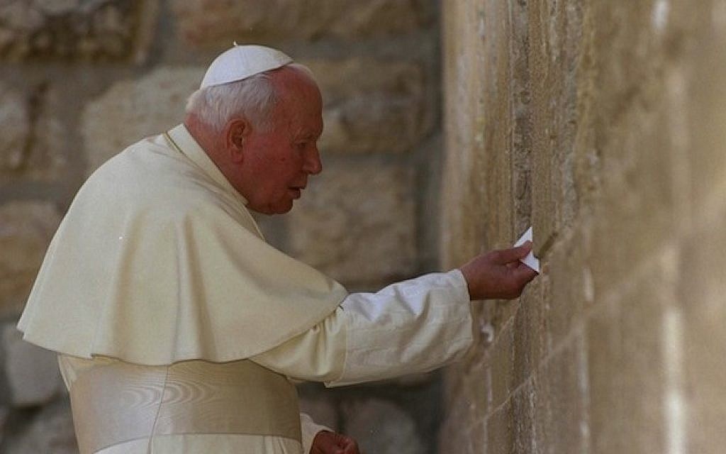 Pope John Paul II places a letter between the stones of Jerusalem’s Western Wall on March 26, 2000. (photo credit: Amos Ben Gershom/Israel Government Press Office via Getty Images/JTA)