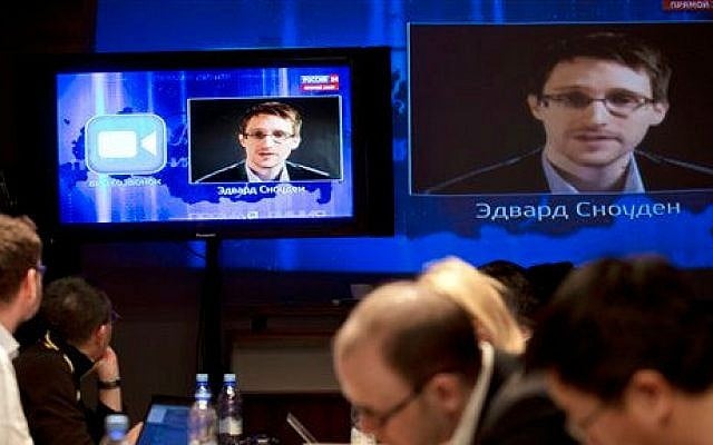 Edward Snowden, displayed on television screens, asks a question to Russian President Vladimir Putin during a nationally televised Q&A session, in Moscow, April 17, 2014. (photo credit: AP/Pavel Golovkin) Edward Snowden, displayed on television screens, asks a question to Russian President Vladimir Putin during a nationally televised Q&A session, in Moscow, April 17, 2014. (photo credit: AP/Pavel Golovkin)