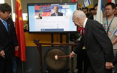 President Shimon Peres strikes a gong at the Beijing ceremony launching his Weibo page (photo credit: Amos Ben Gershom/GPO)