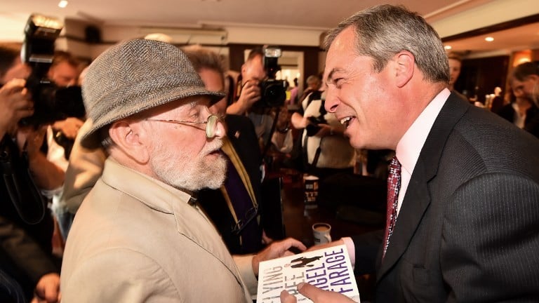 UK Independence Party (UKIP) leader Nigel Farage (R) smiles after signing a copy of his book for a supporter in Basildon in Essex, east of London, on May 23, 2014, as results continue to come in from local council elections in Britain. (photo credit: Ben Stansall/AFP) UK Independence Party (UKIP) leader Nigel Farage (R) smiles after signing a copy of his book for a supporter in Basildon in Essex, east of London, on May 23, 2014, as results continue to come in from local council elections in Britain. (photo credit: Ben Stansall/AFP)