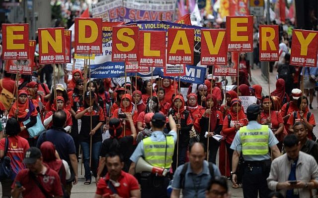 Migrant workers from Indonesia carry placards which collectively read "End Slavery" (top) during a Labour Day rally in Hong Kong on May 1, 2014. (AFP/Anthony Wallace) Migrant workers from Indonesia carry placards which collectively read "End Slavery" (top) during a Labour Day rally in Hong Kong on May 1, 2014. (AFP/Anthony Wallace)