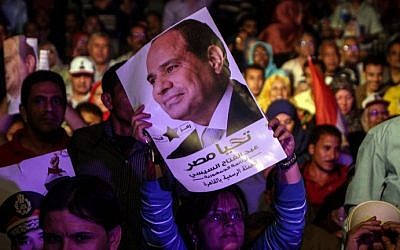 An Egyptian supporter of Egypt's former army chief Abdel Fattah al-Sisi holds his portrait during a gathering in the capital Cairo on May 10, 2014. (photo credit: AFP Photo/Mohamed el-Shahed)