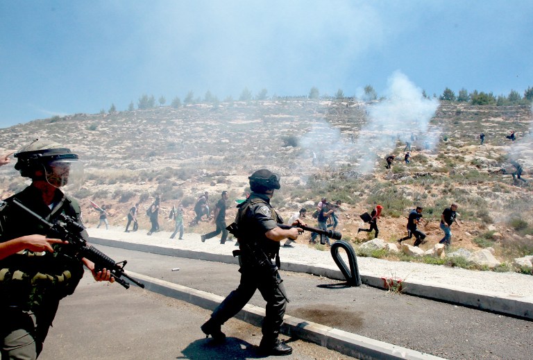 Israeli border police fire tear gas canisters during clashes with Palestinian protesters marking the 66th anniversary of the Nakba on Thursday, May 15, 2014, near the West Bank village of Walajah, south of Jerusalem (photo credit: AFP/Musa al-Shaer) Israeli border police fire tear gas canisters during clashes with Palestinian protesters marking the 66th anniversary of the Nakba on Thursday, May 15, 2014, near the West Bank village of Walajah, south of Jerusalem (photo credit: AFP/Musa al-Shaer)
