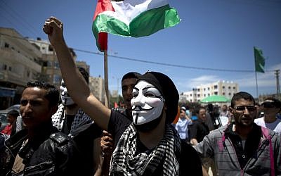 A Palestinian demonstrator, wearing a Guy Fawkes mask, takes part in a rally near the border with Israel, east of Gaza City, on May 15, 2014, to mark Nakba Day. (photo credit: AFP/Mohammed Abed)