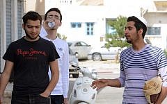 Tunisian Jewish youngsters chat on May 16, 2014 in the Hara Kebira district on the Tunisian island of Djerba, the site of an annual pilgrimage. (photo credit: Fethi Belaid/AFP)