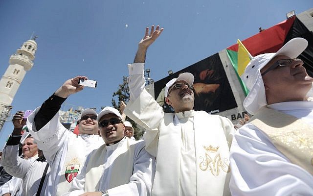 Priests take pictures and wave to Pope Francis upon his arrival to an open-air mass in the Manger Square on May 25, 2014, outside the Church of the Nativity in the West Bank Biblical town of Bethlehem. (photo credit: AFP PHOTO/POOL/Fadi Arouri)