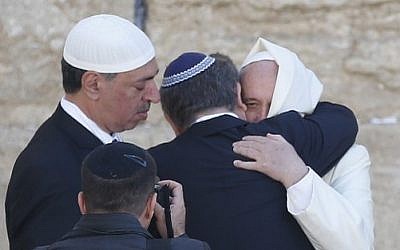 Pope Francis hugs two close Jewish and Muslim friends traveling with him at the Western Wall in Jerusalem's Old City on May 26, 2014. (photo credit: AFP/Thomas Coex)