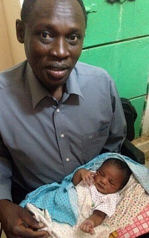A handout picture taken on May 28, 2014, and released by the family on May 30, shows Daniel Wani, a US citizen originally from South Sudan, carrying his newborn daughter Maya at the women's prison in Khartoum's twin city of Omdurman (photo credit:AFP/HO/FAMILY)