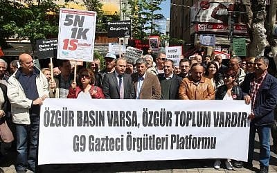 File: Turkish journalists stand behind a banner reading "If you have a free press, there is a free society -- the Gaztec organizations G9 Platform" (a journalists' association) as they protest against attacks on journalists and in support of freedom of the press during a demonstration in Ankara on May 3, 2014. (Adem Altan/AFP)