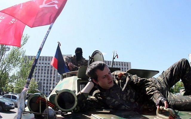 A pro-Russian separatist rests on an armoured vehicle parked in front of the regional state building in eastern Ukrainian city of Donetsk on May 10, 2014, n the eve of an independence referendum. (photo credit: Alexander Khudoteply/AFP) A pro-Russian separatist rests on an armoured vehicle parked in front of the regional state building in eastern Ukrainian city of Donetsk on May 10, 2014, n the eve of an independence referendum. (photo credit: Alexander Khudoteply/AFP)
