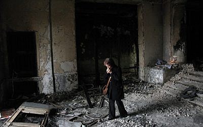 A woman stands on May 10, 2014 in the burned trade union building in Odessa, southern Ukraine, as people gather outside the building during an Orthodox ceremony to mourn the death of pro-Russian militants killed nine days earlier.  (photo credit: AFP/ANATOLII STEPANOV)