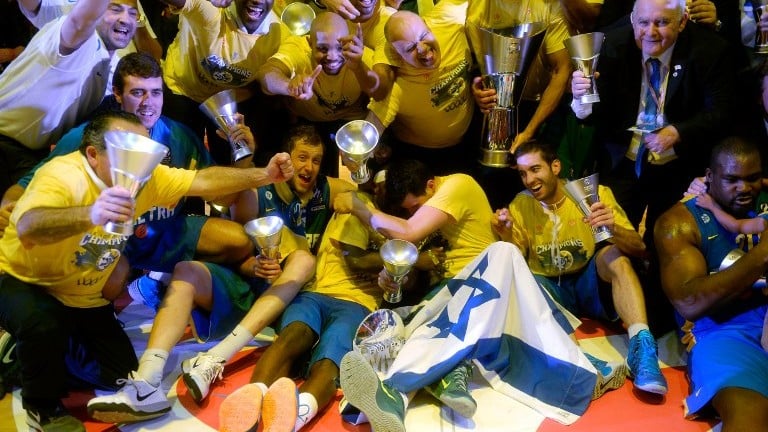 Maccabi Tel Aviv players celebrate their victory at the end of their Euroleague 2014 3rd place Final Four basketball game against Real Madrid, on May 18, 2014, at the Mediolanum stadium in Assago, Italy. (photo credit: Olivier Morin/AFP)