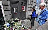 People pay their respects in front of a makeshift memorial at the entrance of the Jewish Museum in Brussels, on May 25, 2014. (AFP/Georges Gobet)