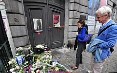 People pay their respects in front of a makeshift memorial at the entrance of the Jewish Museum in Brussels following a deadly terrorist attack, on May 25, 2014. (AFP/Georges Gobet)