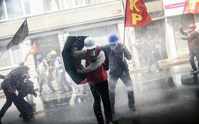 Turkish protesters take cover as riot police use a water cannon to disperse a May Day rally in Taksim Square in Istanbul on May 1, 2014. (AFP/Bulent Kilic) Turkish protesters take cover as riot police use a water cannon to disperse a May Day rally in Taksim Square in Istanbul on May 1, 2014. (AFP/Bulent Kilic)