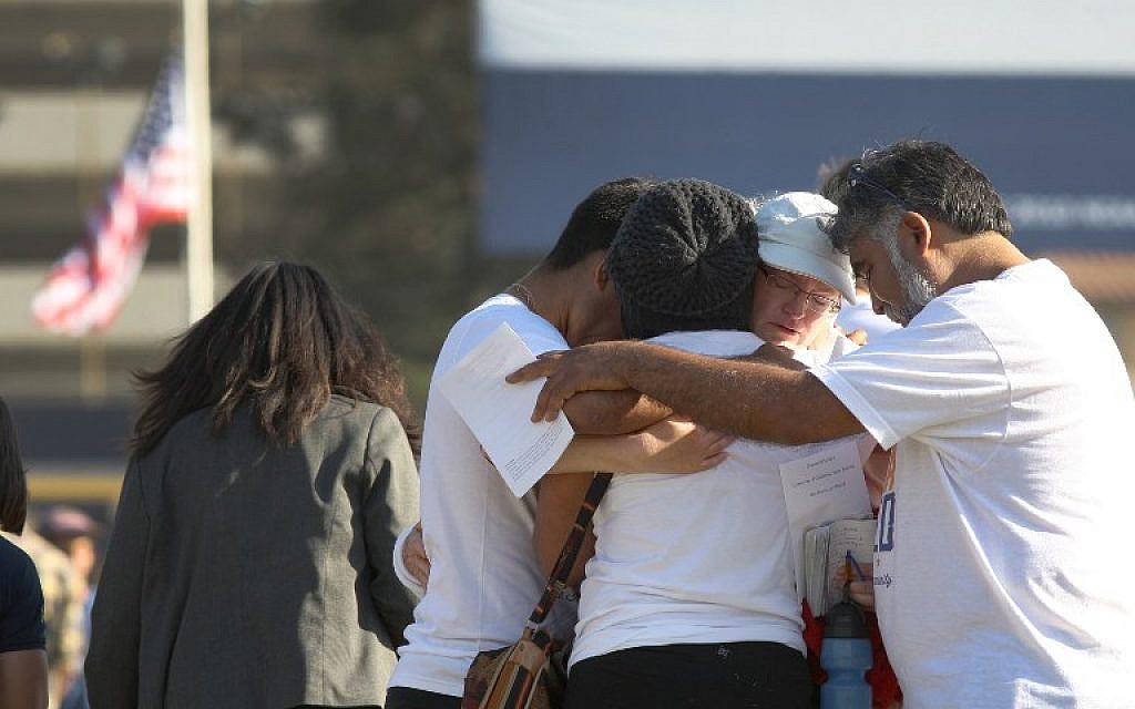 People hug at a public memorial service on the Day of Mourning and Reflection for the victims of a killing spree at University of California, Santa Barbara on May 27, 2014 in Isla Vista, California. (photo credit: AFP/David McNew/Getty Images) People hug at a public memorial service on the Day of Mourning and Reflection for the victims of a killing spree at University of California, Santa Barbara on May 27, 2014 in Isla Vista, California. (photo credit: AFP/David McNew/Getty Images)