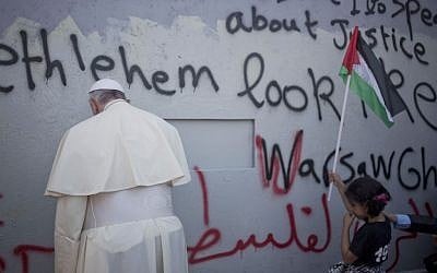 Pope Francis stands at Israel's West Bank security barrier on his way to a mass in Manger Square in Bethlehem on Sunday, May 25, 2014. (photo credit: AP Photo/Ariel Schalit)