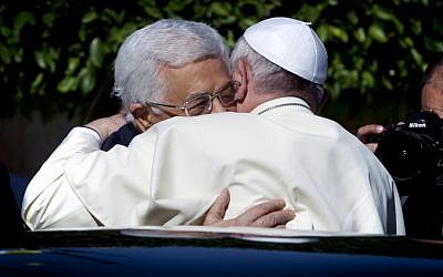 Palestinian Authority President Mahmoud Abbas (left), and Pope Francis (right) hug each other as Francis arrives at the PA headquarters in the West Bank city of Bethlehem, May 25, 2014. (photo credit: AP/Nasser Nasser)