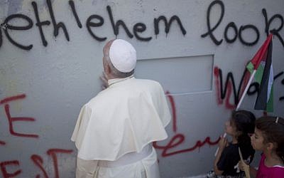 Pope Francis prays at Israel's security barrier on his way to a mass in Manger Square next to the Church of the Nativity, traditionally believed to be the birthplace of Jesus Christ in the West Bank city of Bethlehem on Sunday, May 25, 2014. (AP Photo/Ariel Schalit)