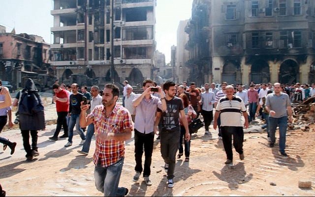 In this photograph made on a government-led media tour, Syrian civilians return to Homs, Syria on Friday, May 9, 2014, where bulldozers cleared rubble from the streets of battle-scarred districts in the central Syrian city. (AP Photo) In this photograph made on a government-led media tour, Syrian civilians return to Homs, Syria on Friday, May 9, 2014, where bulldozers cleared rubble from the streets of battle-scarred districts in the central Syrian city. (AP Photo)