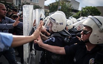 Riot police try to stop protesters attacking the offices of Prime Minister Recep Tayyip Erdogan's Justice and Development Party in Soma, Turkey, during the PM's visit on May 14, 2014. (photo credit: AP/Emrah Gurel)