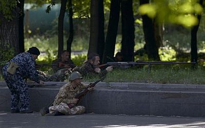 Pro-Russian insurgents aim their rifles during fighting around the airport outside Donetsk, Ukraine, Monday, May 26, 2014. (photo credit: AP/Vadim Ghirda)
