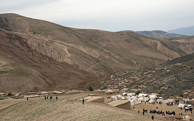 Survivors walk near the site of Friday's landslide that buried Abi-Barik village in Badakhshan province, northeastern Afghanistan, Sunday, May 4, 2014. (Photo credit: AP/Massoud Hossaini) Survivors walk near the site of Friday's landslide that buried Abi-Barik village in Badakhshan province, northeastern Afghanistan, Sunday, May 4, 2014. (Photo credit: AP/Massoud Hossaini)
