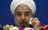 Iranian President Hassan Rouhani wipes his cheek as he speaks during a press conference at a hotel in Shanghai, China, on Thursday, May 22, 2014. (photo credit: AP Photo/Ng Han Guan)