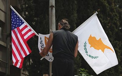 A municipality worker places a US flag, left and Cypriot flag, on an electricity column, on a street in divided capital Nicosia, Cyprus, Tuesday, May 20, 2014. (photo credit: AP/Petros Karadjias)