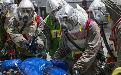 Israeli soldiers in masks and protective suits treat a dummy during a drill of the Home Front Command on May 29, 2013. (photo credit: Flash90)