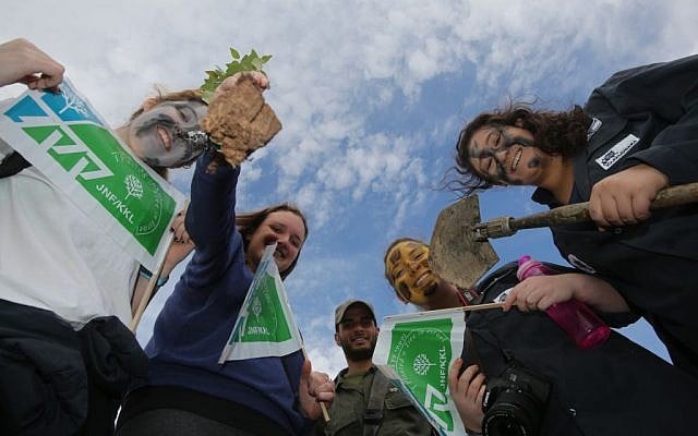 Israelis holding Jewish National Fund signs in the West Bank settlement of Michmash in January 2014 (Yossi Zamir/Flash 90)