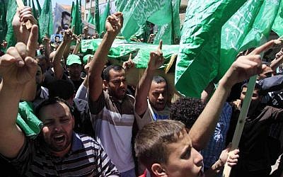 Palestinian mourners wave the green flag of the Islamist movement Hamas at a funeral on April 30, 2014, in the West Bank city of Ramallah. (photo credit: Issam Rimawi/Flash90)