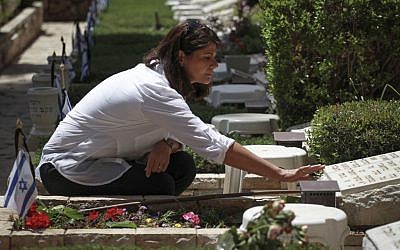 A woman who works at the Mount Herzl Military Cemetery checks the grave of Tzion Tayeb, who the military said had died in the Yom Kippur War in 1973, on Sunday, May 4, 2014, on the eve of the Israeli Remembrance Day. The deceased soldier's family said they dug up the grave last Friday only to find it empty. They had decided to open the grave because they claimed that the State had misidentified his body. The case is currently under investigation. (Photo credit: Hadas Parush/Flash 90)