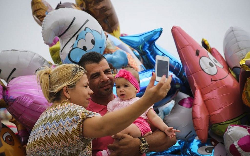 A family take a selfie on the Tel Aviv beach boardwalk. (illustrative photo credit: Hadas Parush/Flash 90) A family take a selfie on the Tel Aviv beach boardwalk. (illustrative photo credit: Hadas Parush/Flash 90)