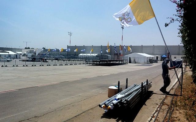 A man setting up flags as part of preparations at the Ben Gurion Airport for the arrival of Pope Francis, on May 20, 2014. (photo credit: Tzahi Ben Ami/Flash 90)