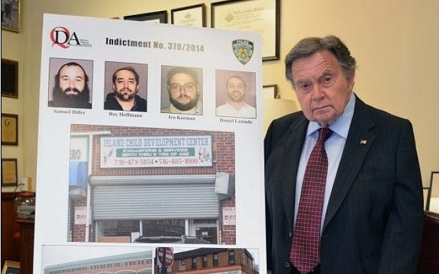 Queens District Attorney Richard A. Brown stands next to pictures of the 4 men indicted for stealing from a Far Rockaway special needs school (photo credit: Courtesy/Queens District Attorney) Queens District Attorney Richard A. Brown stands next to pictures of the 4 men indicted for stealing from a Far Rockaway special needs school (photo credit: Courtesy/Queens District Attorney)