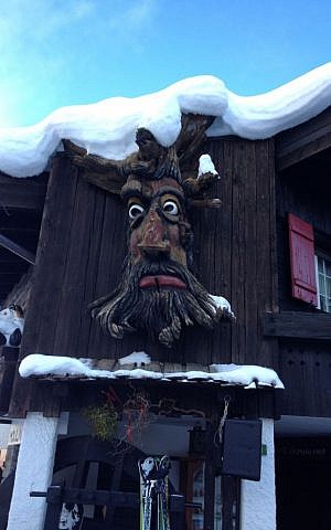Wooden masks are hung throughout the village, but in fact, are not locally made (photo credit: Jessica Steinberg/Times of Israel)