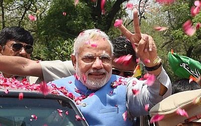 Supporters shower flower petals on opposition Bharatiya Janata Party (BJP) leader and India's next prime minister Narendra Modi as he arrives at the party headquarters in New Delhi, India, Saturday, May 17, 2014. (Photo credit: AP)