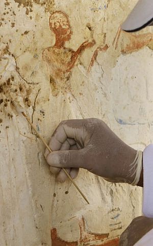 An Egyptian conservator works at the site of a newly-discovered tomb dating back to around 1100 B.C. at the Saqqara archaeological site, 30 kilometers (19 miles) south of Cairo, Egypt, Thursday, May 8, 2014.  (photo credit: AP Photo/Amr Nabil)