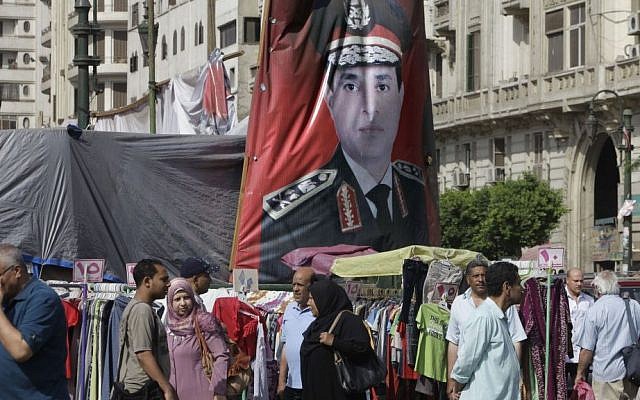 Egyptians walk past a banner with a portrait of Egyptian Presidential hopeful Abdel-Fattah el-Sissi at a market in Cairo, Egypt, on Saturday, May 17, 2014. (photo credit: AP Photo/Amr Nabil) Egyptians walk past a banner with a portrait of Egyptian Presidential hopeful Abdel-Fattah el-Sissi at a market in Cairo, Egypt, on Saturday, May 17, 2014. (photo credit: AP Photo/Amr Nabil)