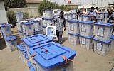 Electoral workers carry ballot boxes at a counting center in Basra, Iraq's second-largest city, May 1, 2014 (photo credit: AP/Nabil Al-Jurani)