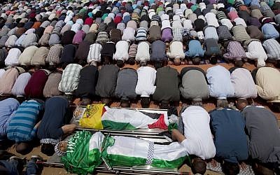Mourners pray for the bodies of Palestinian teens Mohammed Abu Dhaher, front, and Nadim Nawara, behind, during their funeral in the West Bank city of Ramallah, May 16, 2014 (photo credit: AP/Majdi Mohammed)