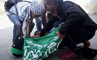 In this Thursday, May 15, 2014, photo, men rush to the aid of Mohammad Abu Daher, 17, moments after he was killed in a clash with Israeli troops near the West Bank city of Ramallah. (AP Photo/Majdi Mohammed, File)