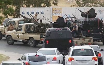 In this image made from video provided by the Libyan national army via AP Television, vehicles with heavy artillery of the Tripoli joint security forces move closer to the parliament building after troops of Gen. Khalifa Hifter targeted Islamist lawmakers and officials at the parliament in Tripoli, Libya, on May 18, 2014.  (Photo credit: AP/Libyan national army/file)