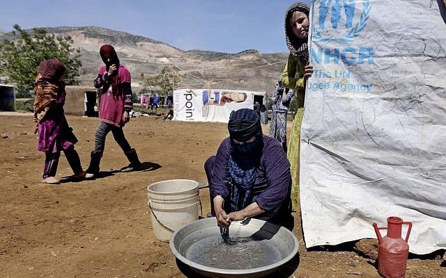 In this Tuesday, April 29, 2014 photo, Halbiya, 50, who fled her home from Deir al-Zour, washes her hands after working on a field, at a Syrian refugee camp, near the eastern town of Kab Elias, Lebanon. (photo credit: AP/Bilal Hussein) In this Tuesday, April 29, 2014 photo, Halbiya, 50, who fled her home from Deir al-Zour, washes her hands after working on a field, at a Syrian refugee camp, near the eastern town of Kab Elias, Lebanon. (photo credit: AP/Bilal Hussein)